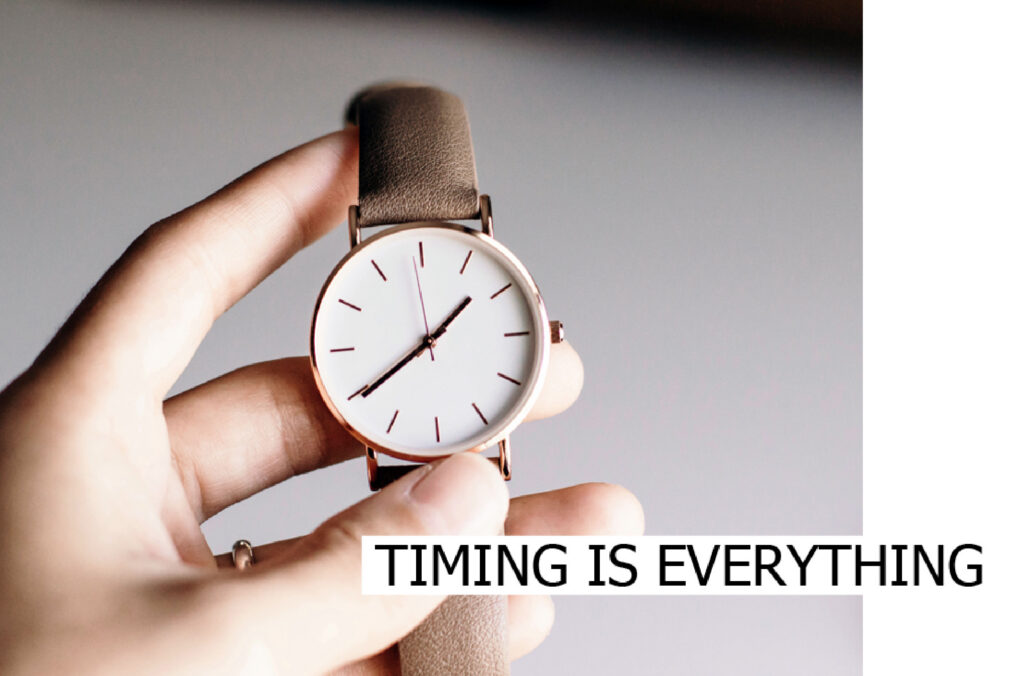 Hand holding a wristwatch with the caption Timing is everything