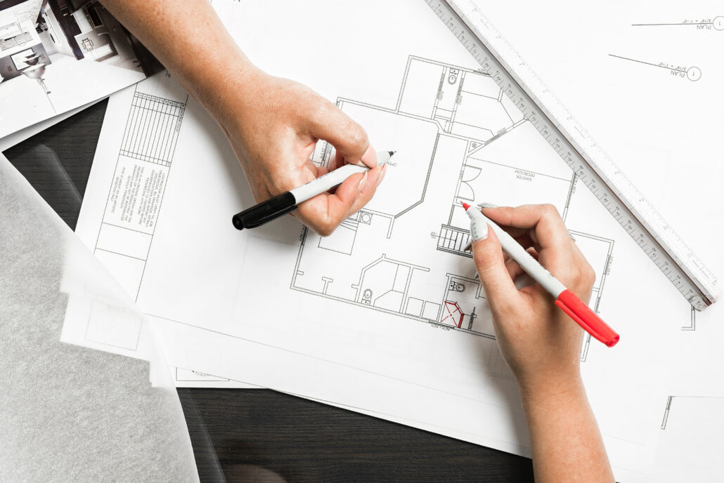 Designer sketching an office floor plan with markers
