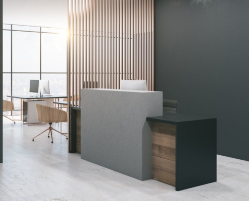 A view of the lobby of an office. You can see an empty reception desk with multiple heights in the middle of the room.